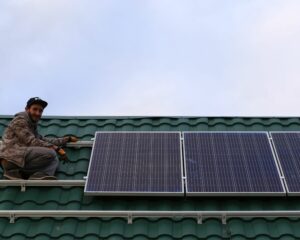 Personne sur le toit d'une maison, en train d'installer des panneaux solaires