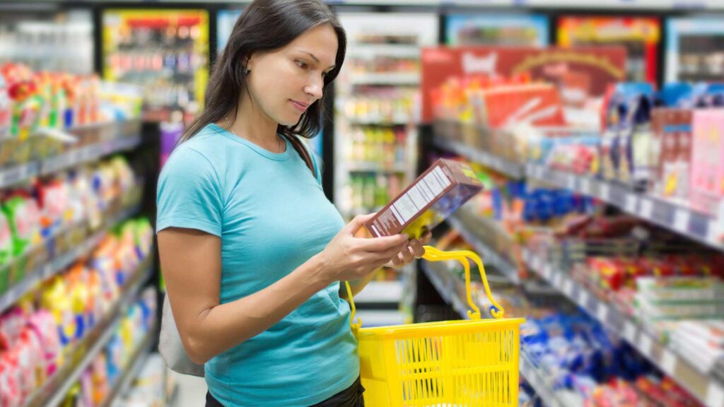 femme qui analyse un produit au super marché